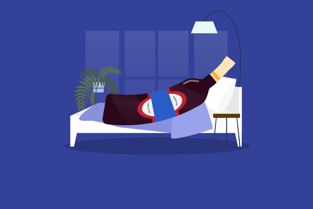 bottle of alcohol resting on a bed