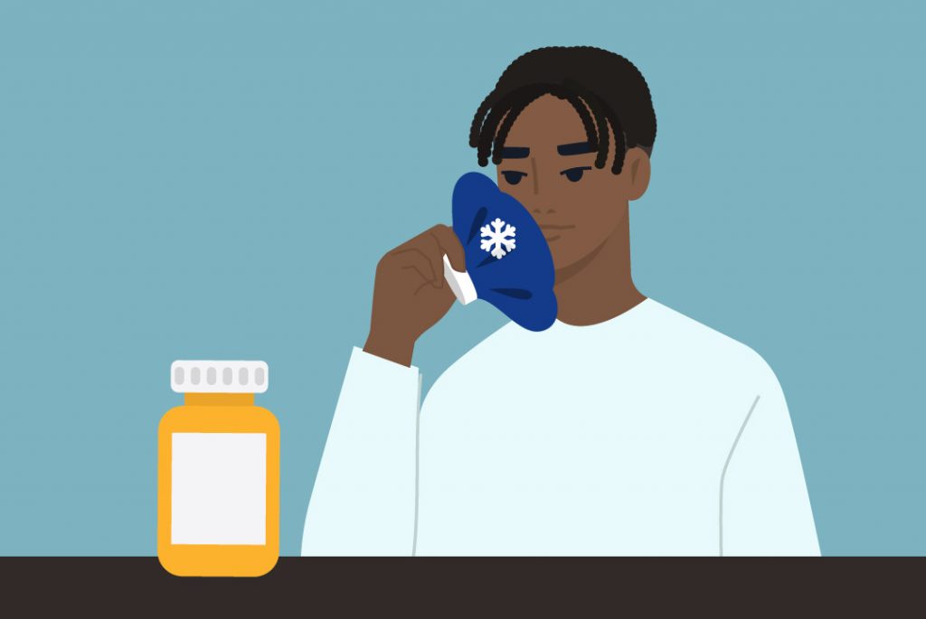 person icing jaw, looking at pill bottle