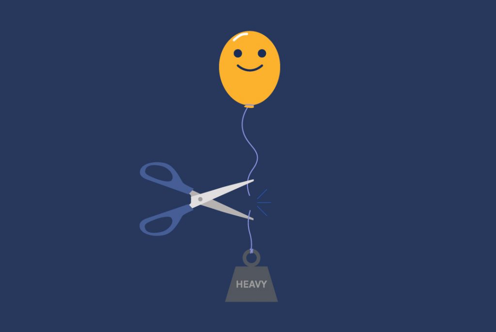 scissors cutting a ribbon where a weight is holding down a happy face balloon