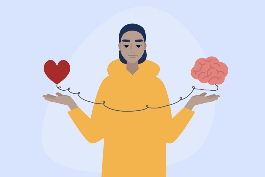 person holding a heart and brain connected by wire