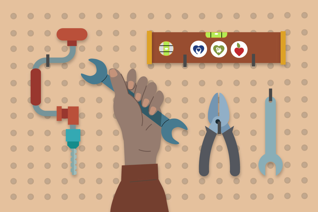 a hand holds up a tool in front of a pegboard of tools